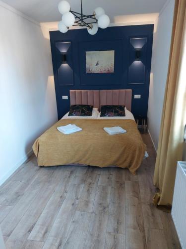 a bedroom with a bed with a blue headboard at Miodowy Apartament in Złotów