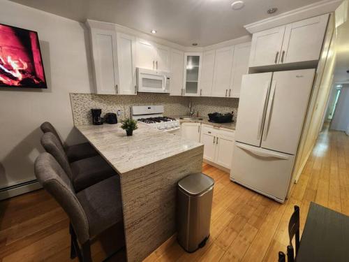 a kitchen with white cabinets and a island in a kitchen at Cosy Modern Home Mins to NYC! in Union City