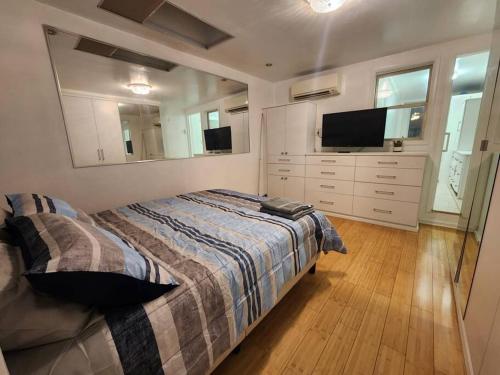 a bedroom with a bed and a flat screen tv at Cosy Modern Home Mins to NYC! in Union City