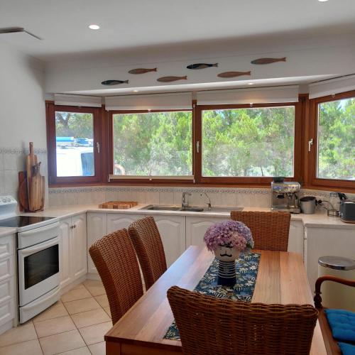 a kitchen with a table with a vase of flowers on it at Strandmarken in Island Beach