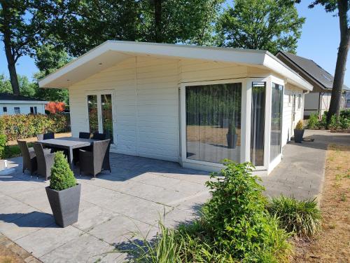 - un pavillon avec une table et des chaises sur la terrasse dans l'établissement Limburg-Chalet, à Susteren