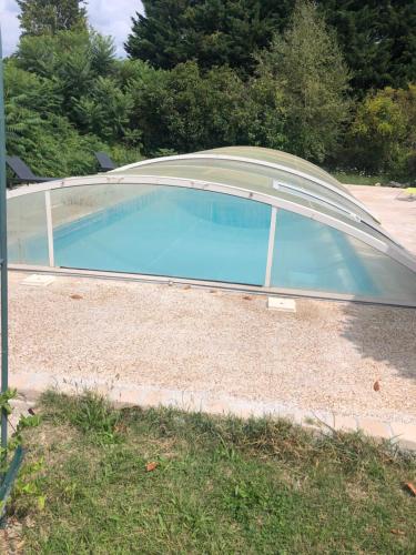 une piscine avec une couverture sur une maison dans l'établissement Cottage La Halouère, à Saint-Philbert-du-Peuple