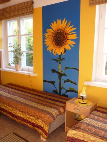 a bedroom with a sunflower painted on the wall at Marigolds in Sigulda