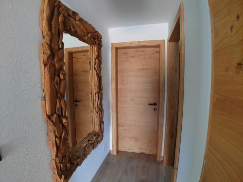 a mirror hanging on a wall next to a door at AlpiNest Feriendorf Lungau in Mariapfarr