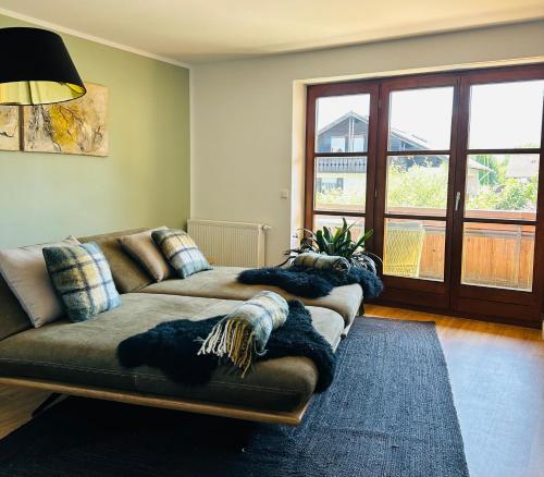 a living room with a couch and a large window at annes*glück in Füssen