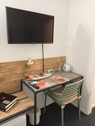 a desk with a chair and a television on a wall at Mediterrâneo Madeira in São Vicente