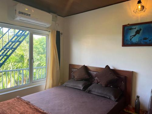 a bedroom with a bed and a large window at J.J bed and breakfast in Port Blair