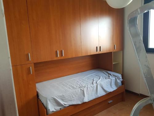 Bisceglie Aparthotel في ميلانو: غرفة نوم بها دواليب خشبية وسرير