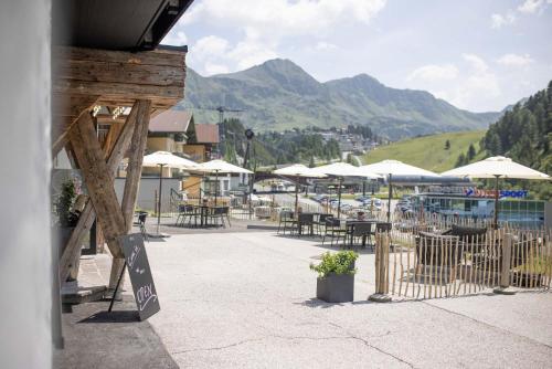 a patio with tables and chairs and umbrellas at CARPE SOLEM Jules in Obertauern