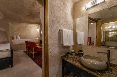 a bathroom with a sink and a bedroom with a bed at The Niche Cave Hotel in Goreme