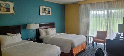 a hotel room with two beds and a window at Chester Inn & Suites in Sharonville