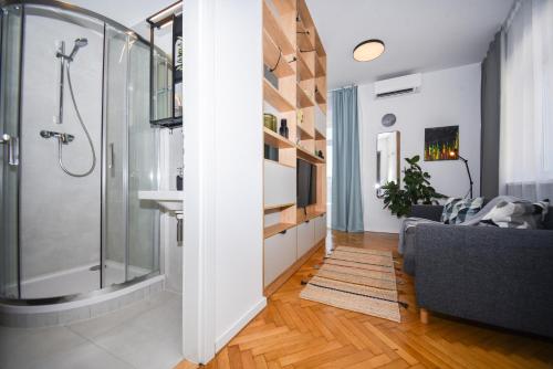 een badkamer met een douche en een woonkamer bij City Center Studio - Comfy & Modern in Bratislava