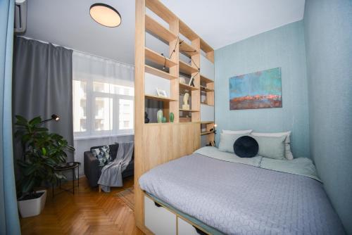 een kleine slaapkamer met een bed en een boekenplank bij City Center Studio - Comfy & Modern in Bratislava