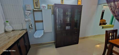 a kitchen with a wooden cabinet in a room at UDUPI HOMESTAY - Garden Villa 5BHK in Udupi