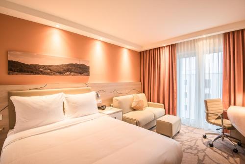 una camera d'albergo con un letto, una sedia e una scrivania di Hampton By Hilton Freiburg a Friburgo in Brisgovia