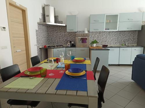 kuchnia ze stołem z talerzami i kieliszkami do wina w obiekcie KuneKune MONOLOCALE w mieście Albissola Marina