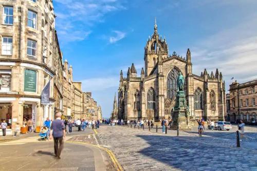 a group of people walking down a street in front of a cathedral at Stylish City Apartment in Edinburgh