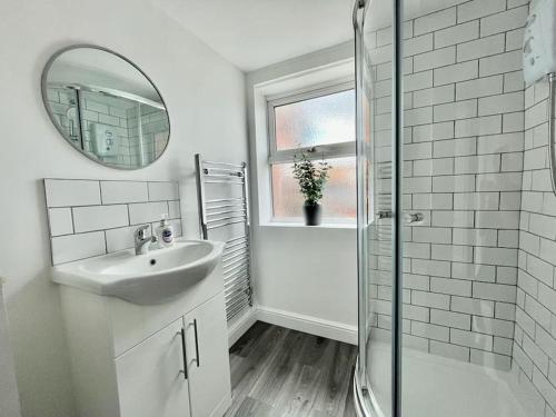 a white bathroom with a sink and a shower at Flat 1 High Street Apartments, One Bed in Wellington