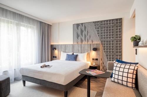 a hotel room with a bed and a couch at Citadines Kurfürstendamm Berlin in Berlin