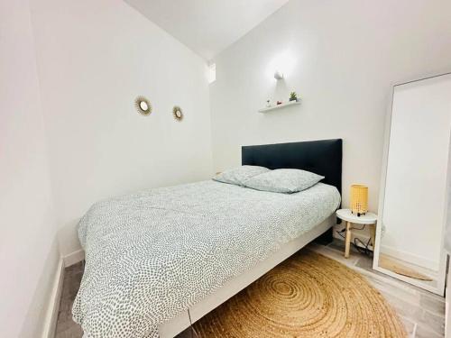 um quarto branco com uma cama e um espelho em L'escale Laonnoise em Laon