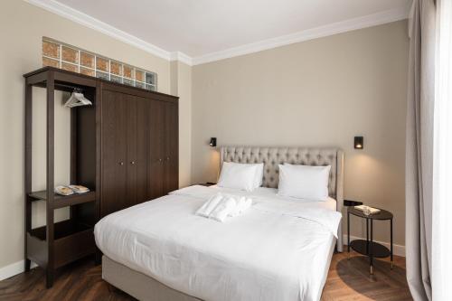 een slaapkamer met een groot bed met witte lakens bij #Primavera: Seafront apt with White tower view in Thessaloniki