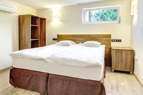 a large bed in a bedroom with a window at Hotel Duchess in Varna City