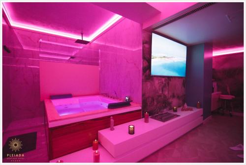 a pink bathroom with a tub and a tv at Pleiada Boutique Hotel & Spa in Iaşi