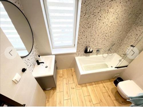 a bathroom with a tub and a sink and a mirror at Pokoje goscinne u Brody in Międzybrodzie Żywieckie