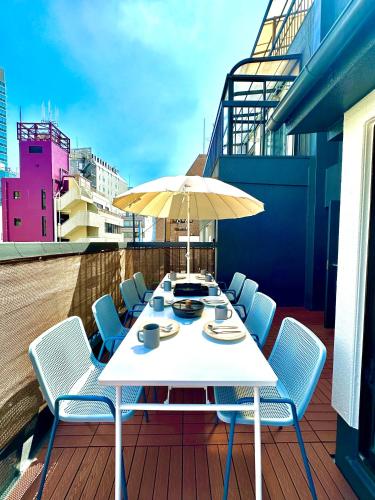 a table with chairs and an umbrella on a balcony at Ueno Retro Flower - Ueno Okachimachi in Tokyo