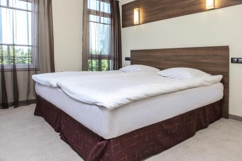a large bed in a room with windows at Hotel Duchess in Varna City