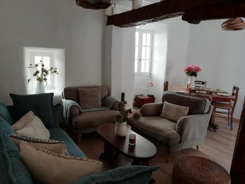 a living room with couches and a table at A Torra in Ville-di-Paraso