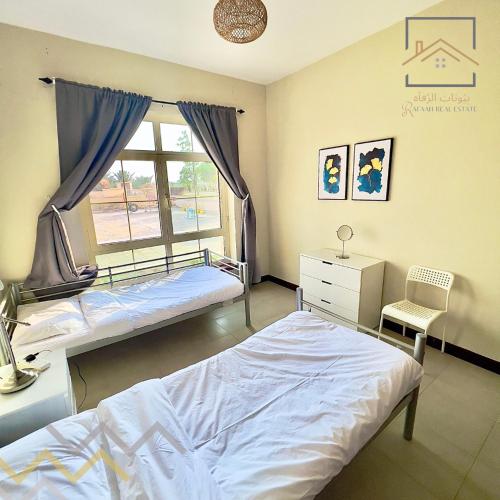 um quarto com 2 camas e uma janela em بِيُوتات الرّفآه - أناقة المرينا em King Abdullah Economic City