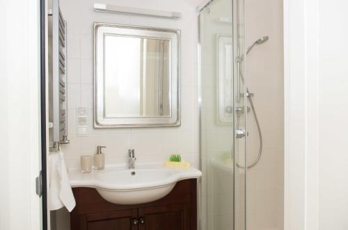een badkamer met een wastafel en een douche bij Apartamenty Królowej in Sopot