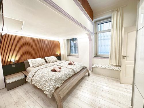 een slaapkamer met een groot bed met 2 roze kussens bij Yes, yes! lovely apartment good amenities Budapest center in Boedapest