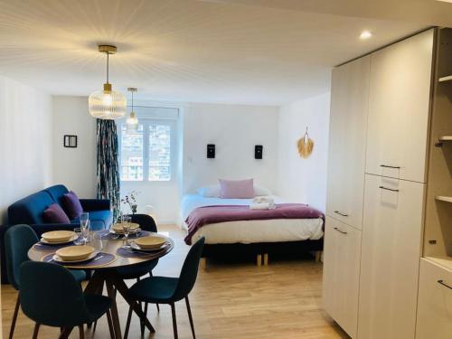 a room with a table and chairs and a bed at Le Cattleya, studio cosy à Rennes in Rennes