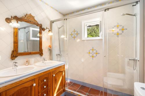 a bathroom with a shower and a sink and a mirror at N'Antiga in Sant Lluis