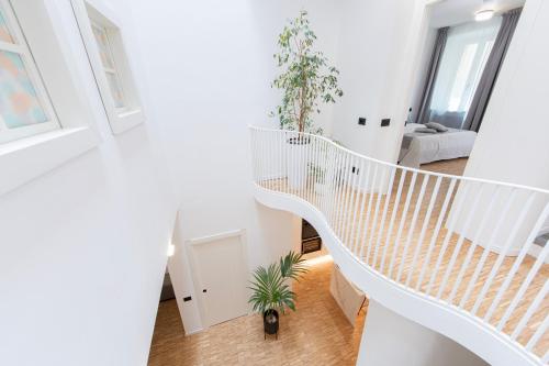 Una escalera de caracol blanca en una habitación blanca en cavaedium guest house, en Arona