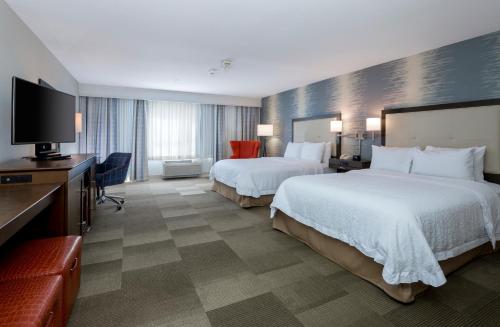 a hotel room with two beds and a flat screen tv at Hampton Inn & Suites San Diego-Poway in Poway