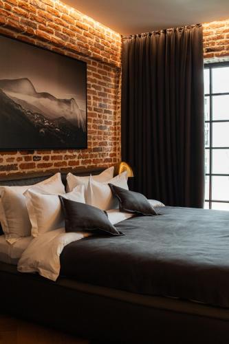a bedroom with a brick wall and a bed with pillows at Mandarin Club House in Batumi