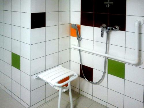 une salle de bain avec une douche avec un banc dedans dans l'établissement VVF Urrugne Saint-Jean-de-Luz Côte Basque, à Urrugne