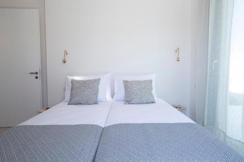 a white bed with two pillows in a bedroom at Villa Sophia-Private Sea Access in Marantochori