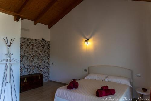 a bedroom with a bed with two red bags on it at Agriturismo Casa del Principe in Torre Bormida