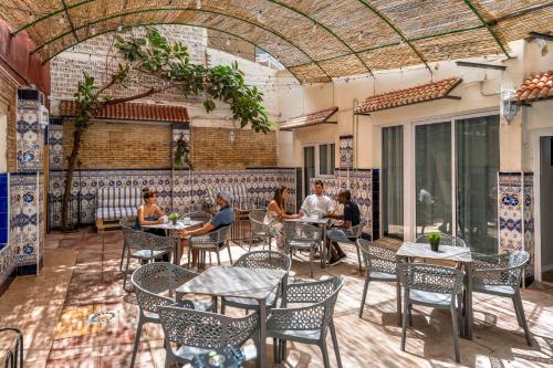 een groep mensen die aan een tafel op een patio zitten bij SOM Hostel By The Venue in Valencia