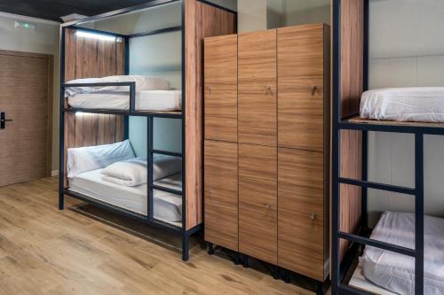 a room with three bunk beds and a closet at SOM Hostel By The Venue in Valencia