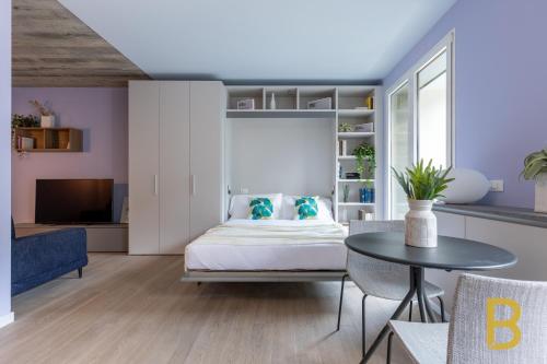una camera da letto con un letto con cuscini blu e un tavolo di BePlace Apartments at Fondazione Prada a Milano