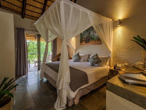 a bedroom with a bed with a canopy at Umbhaba Eco Lodge in Hazyview