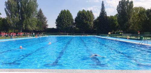 a large swimming pool with people in the water at El Bosque de los Sueños in Cubillos del Sil