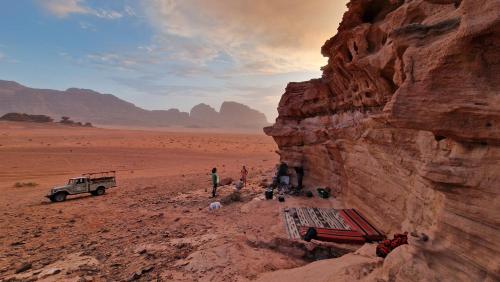 a group of people in the desert with a truck at The White Bedouin in Wadi Rum