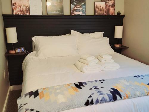 Una cama con dos toallas blancas encima. en White Mountain Barn, en Littleton
