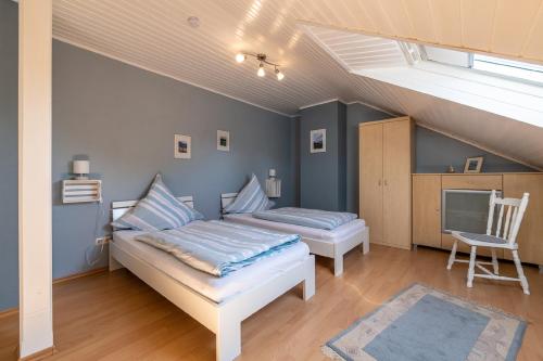1 dormitorio con 1 cama y 1 silla en Ferienwohnung Am Steinchen, en Mettlach